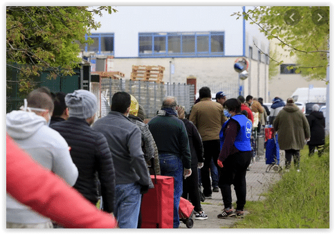 Familias esperando a recibir comida en un banco de alimentos